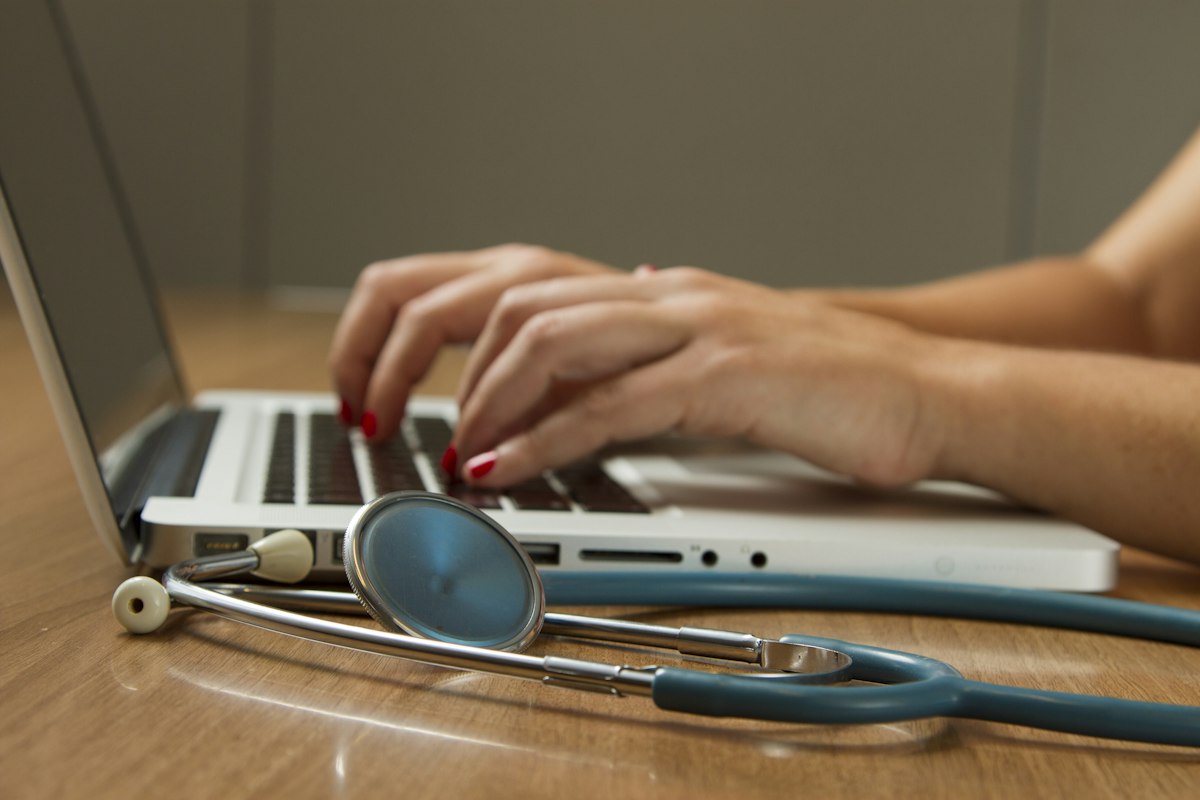 Profissional de saúde analisando prontuário e documentos médicos